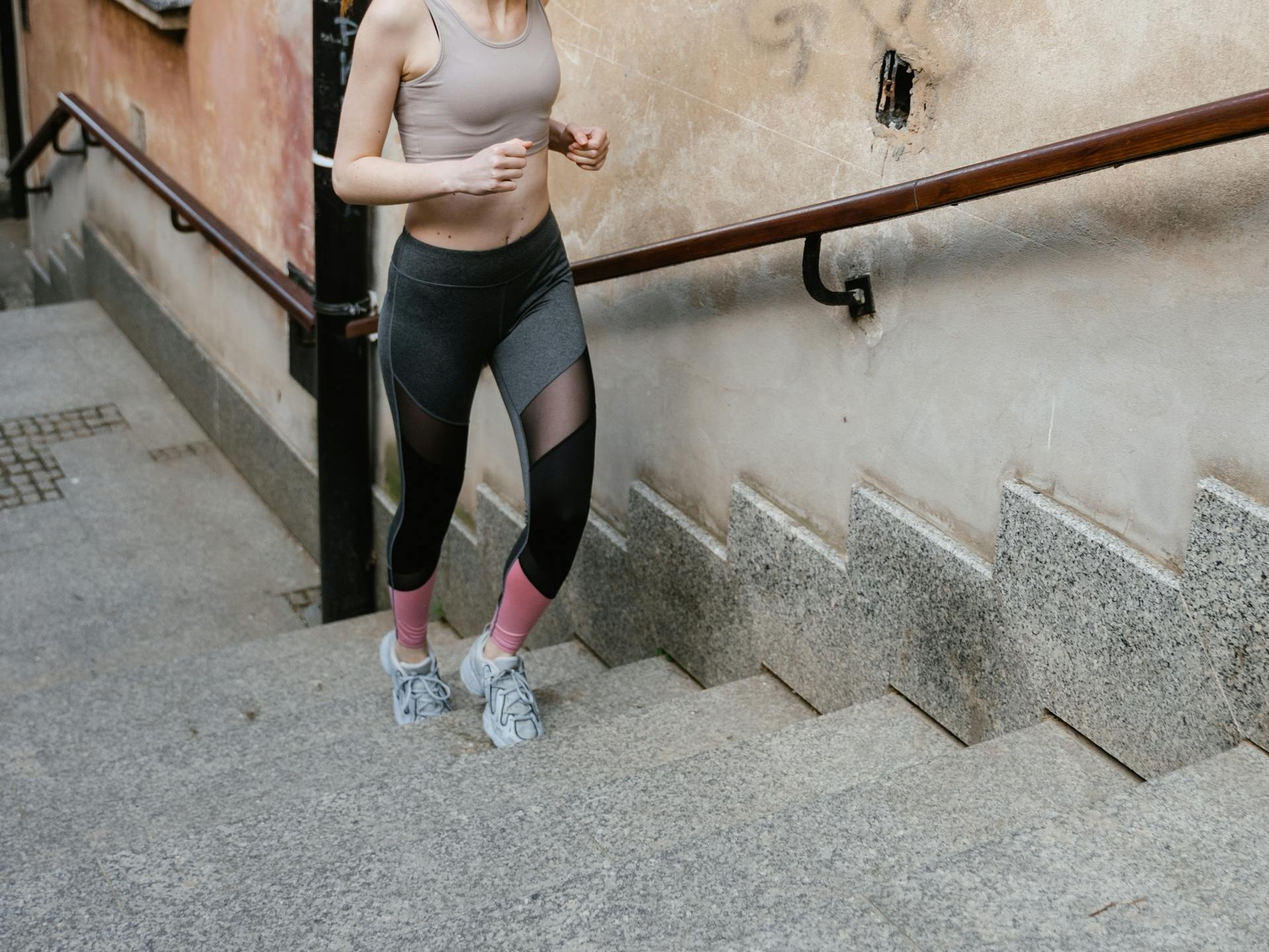 Eine sportliche Frau läuft eine Treppe hoch.