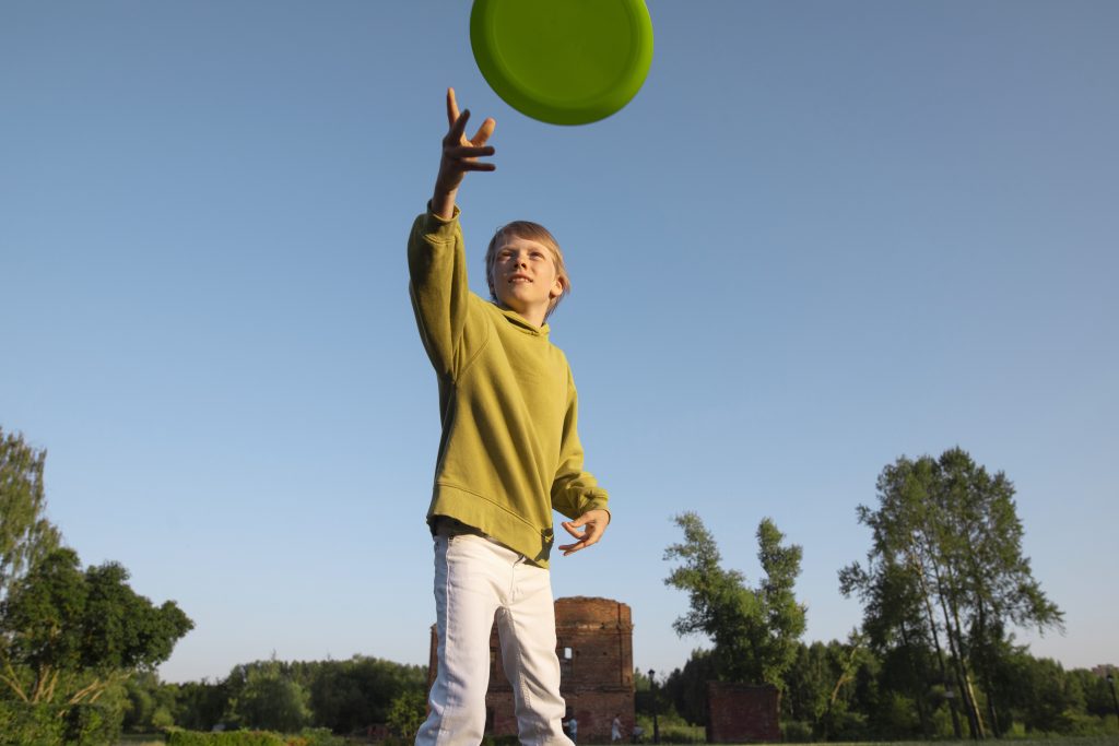 Ein Junge wirft eine Frisbee-Scheibe.