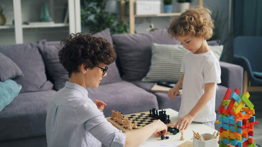 Ein Kind und seine Mutter spielen Schach.