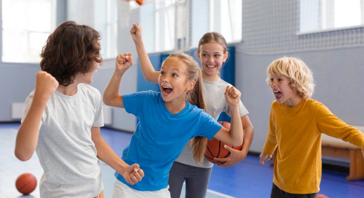 Kinder in einer Sporthalle freudestrahlend und jubilierend.