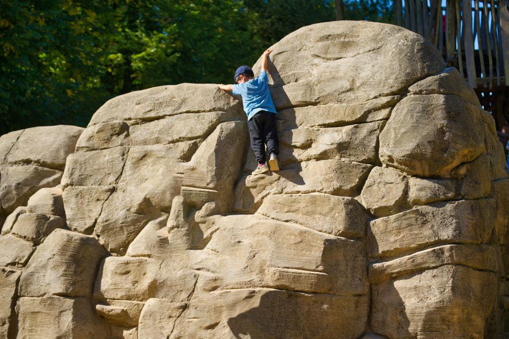 Ein Kind erklettert einen kleinen Felsen.